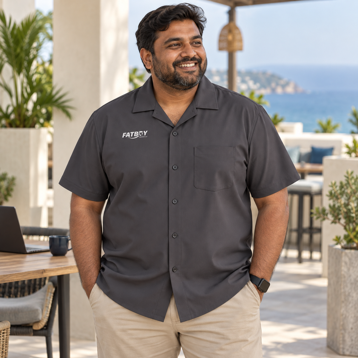Traveler wearing the Graphite Departure shirt at a coastal coworking terrace — lifestyle mockup